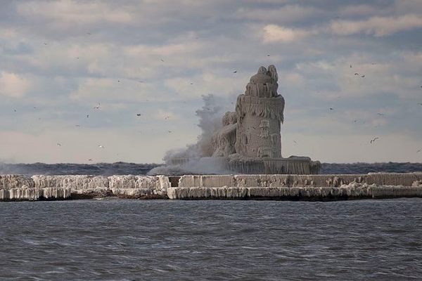 Waves from Lake Erie crash onto Cleveland Harbor West Pierhead Lighthouse as the subzero air temperature causes the water to freeze in multiple layers.